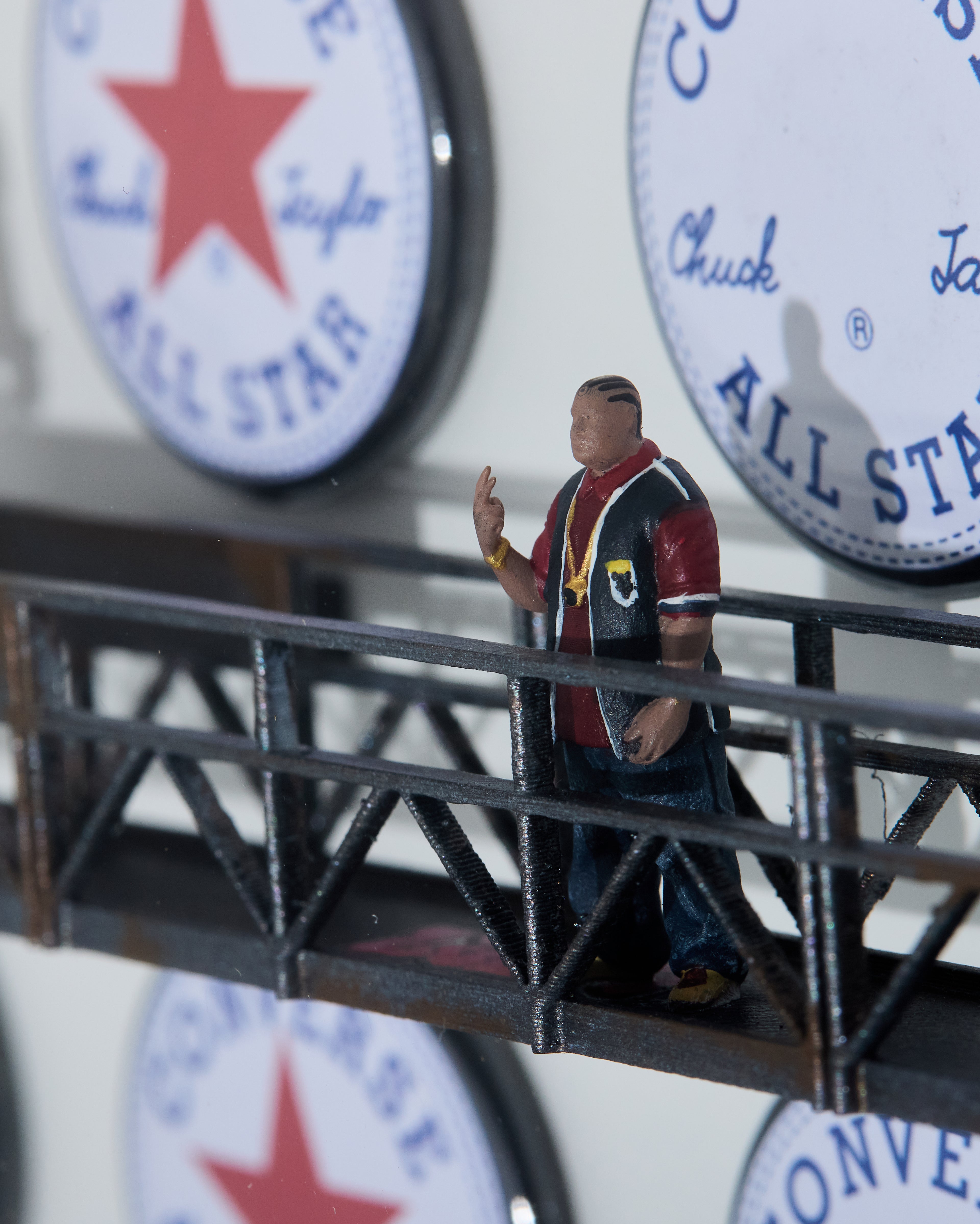 Miniature figurine scale 1/64 standing on a suspended platform with Converse All Star logos in the background