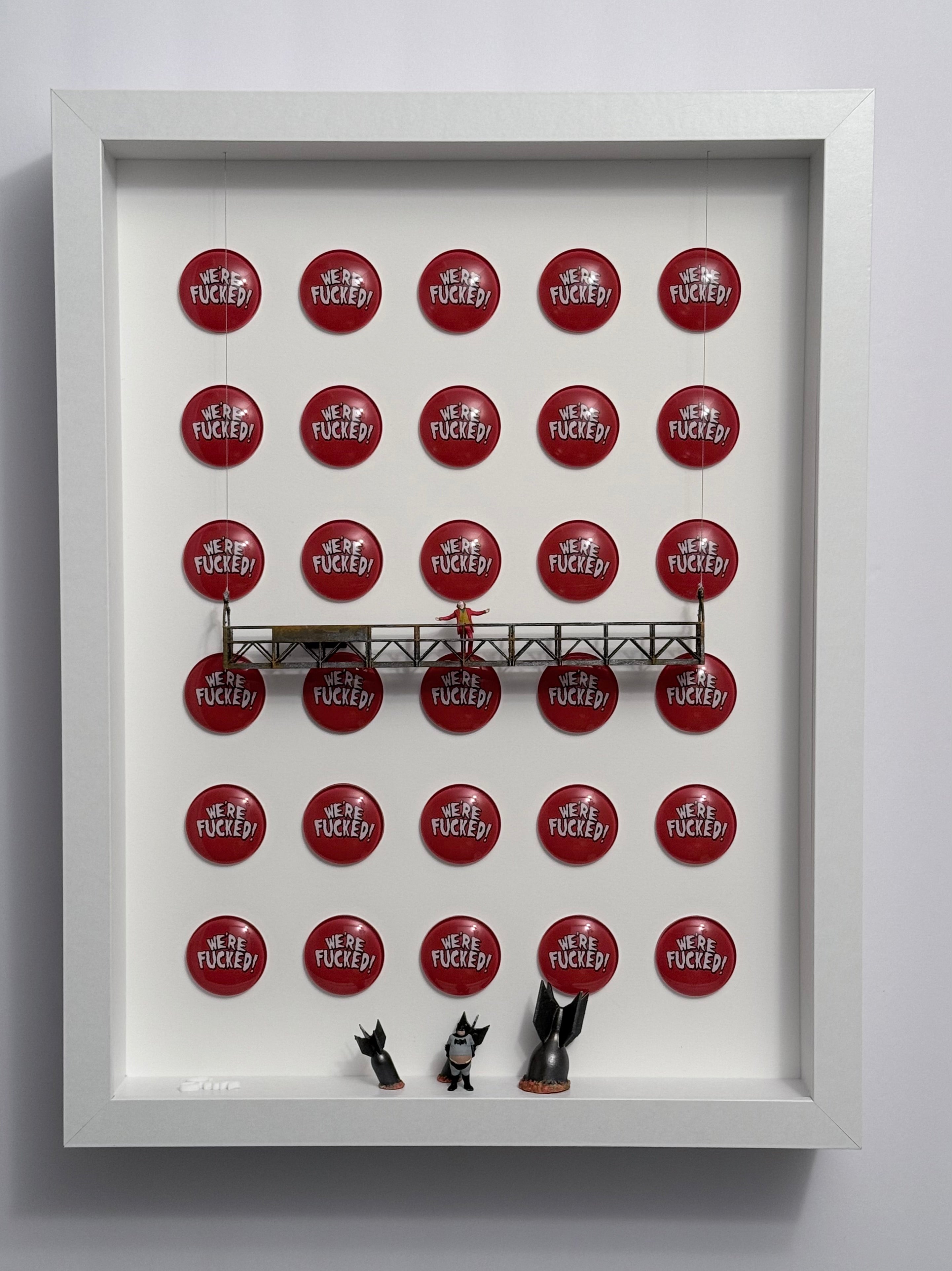 Background of circular red logos reading "we are fucked". On the upper platform shows miniature figurine of the Joker screaming with open arms. below heavy Batman stands near multiple bombs.